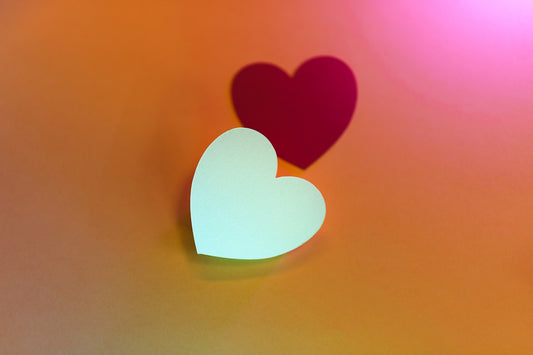 two paper hearts sitting on top of a table